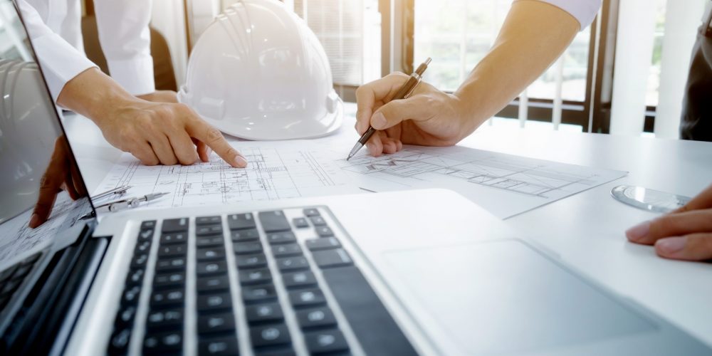 Image of engineer meeting for architectural project. working with partner and engineering tools on workplace vintage tone.