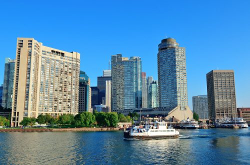 Toronto skyline in the day over lake with urban architecture and boat.