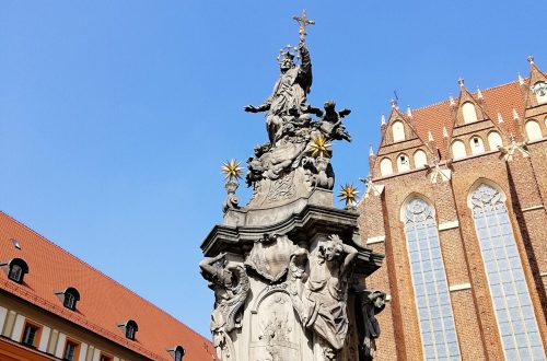 A vertical shot of a statue outside the Cathedral of St. John the Baptist Warsaw, Poland